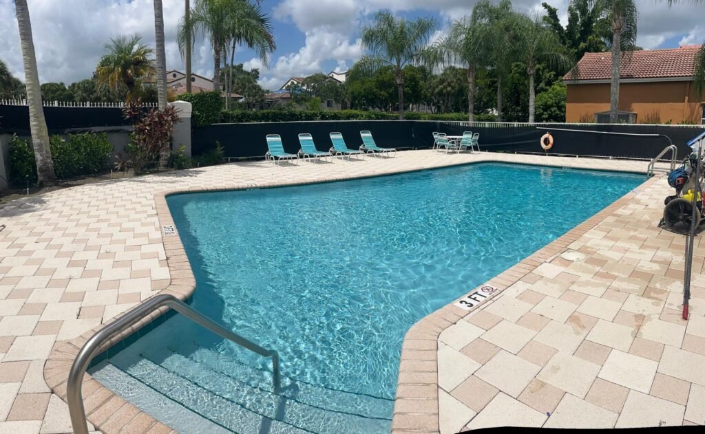 Piscina residencial con spa integrado y borde de ladrillo, con el agua limpia y transparente tras el servicio