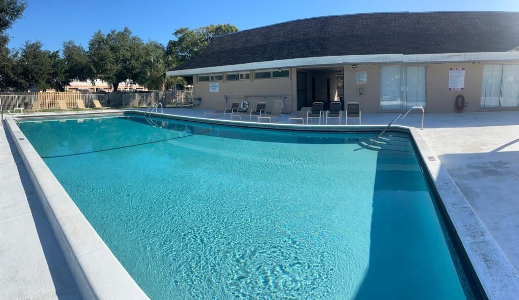 Piscina alargada junto a la terraza de una vivienda moderna, con el agua limpia