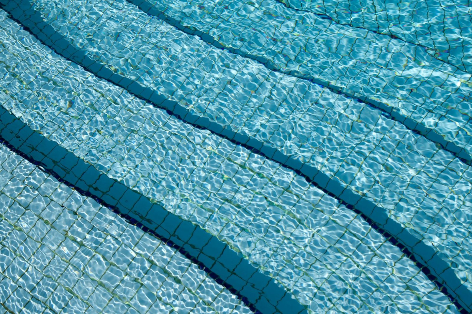 Agua cristalina y cenefa de una piscina atendida por Franko’s Pool Services